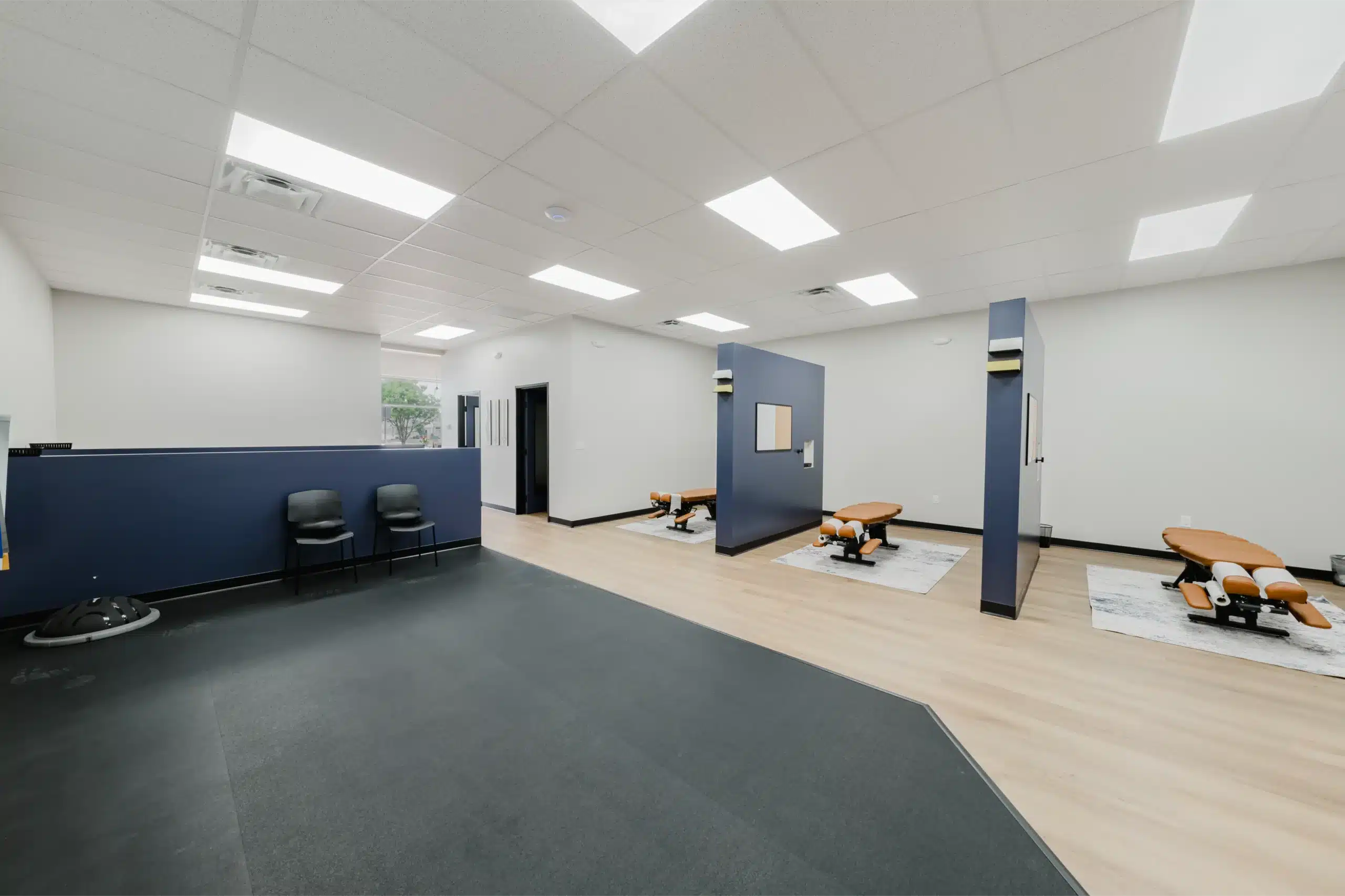 Wide view of a modern chiropractic clinic with adjustment bays and open area, your premier chiropractor in North Fort Worth, also serving as a chiropractor in Alliance and chiropractor near Alliance.